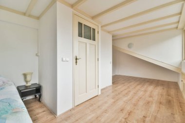 Yatak, pencereli modern minimalist mansard yatak odasının duvarına yakın.