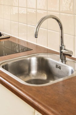 Modern dairenin yemek alanı yakınındaki şık beyaz dolapları ve aletleri olan çağdaş mutfağın içi.