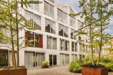 Ağaçlar ve fenerlerle dolu boş bir kaldırım sokağından tuğla evler manzarası