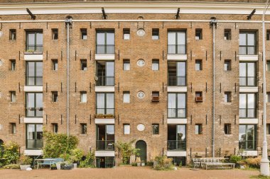 Arabaları, ağaçları ve fenerleri olan boş bir kaldırımdan panorama manzaralı evler.