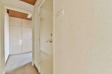 Işık dar koridor, beyaz duvarlarda birçok kapı ve kereste zemininde parlayan lamba