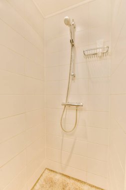 Duş muslukları cam bölmenin yanındaki fayanslı duvara bağlı ve evdeki tuvaletteki süs pervazı.
