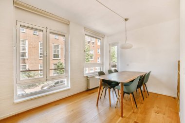 Modern apartmandaki dekorasyonlu ve televizyonlu, rahat koltuğun yanına yerleştirilmiş eski püskü ahşap masa.