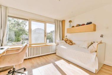 Yatak odasının iç tasarımı, yatak odası ve ahşap gardırop modern dairenin penceresinin kenarına yerleştirilmiş.