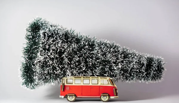 Çatıda Noel ağacı olan kırmızı oyuncak araba, beyaz arka plan.
