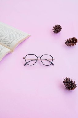 Moda ve güzellik anlayışı kare gözlüklerle yatar, pembe arka planda kadın aksesuarları..