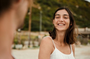 Kafkasyalı çift okyanusun kenarında durup gülümsüyor. 