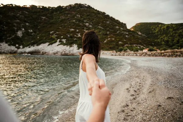 Blanke vrouw wandelen langs het strand met vriendje — Stockfoto