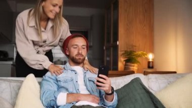 Kafkasyalı mutlu çift hücresel cihazda evde yazarken dinleniyor. 