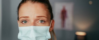 Kafkasyalı kadın hemşire cerrahi maske takıyor.