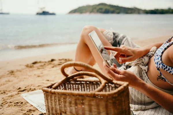 Caucasian female relaxing on beach reading book off digital tablet — Stock Photo, Image
