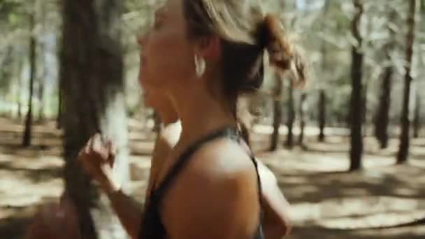 森の中を走る混合レース女子10代は自然の中で運動を楽しむ — ストック動画
