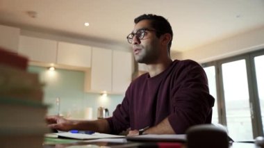 Karışık yarış işadamı, sıcak kahve içiyor, laptoptan kitap okuyor, masa başında oturuyor.