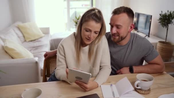 Caucasiano casal sentado feliz na mesa da cozinha beber café triagem finanças para fora — Vídeo de Stock