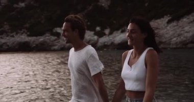 Kumsalda el ele tutuşan mutlu beyaz çift