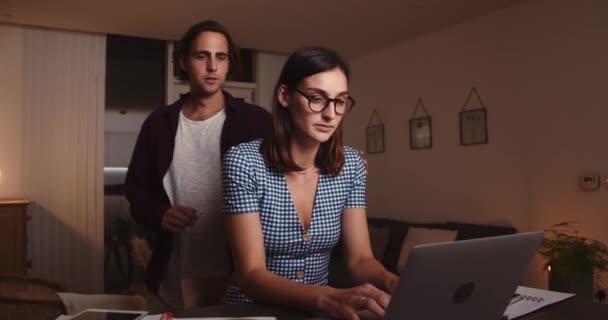 Caucásica mujer trabajando desde casa escribiendo en el ordenador portátil trabajando hasta tarde en la noche — Vídeos de Stock
