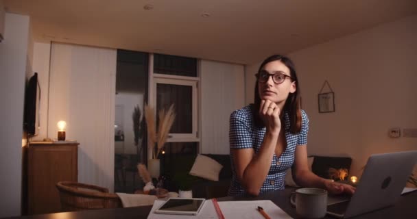 Mujer caucásica trabajando desde casa tarde en la noche escribiendo en el ordenador portátil — Vídeo de stock