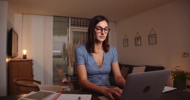 Καυκάσια γυναίκα που εργάζεται από το σπίτι δακτυλογράφηση σε φορητό υπολογιστή κοιτάζοντας έντονα στην οθόνη — Αρχείο Βίντεο