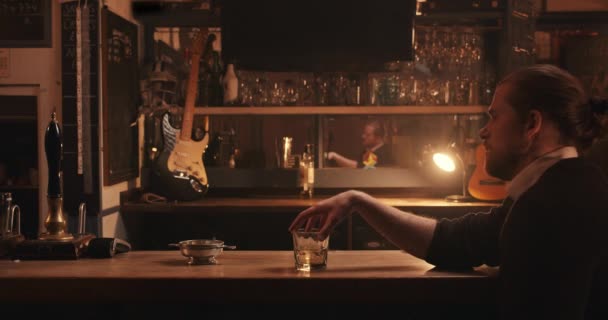 Caucásico cliente masculino sentado solo en el bar bebiendo whisky — Vídeos de Stock