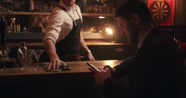 Barman caucásico limpiando la barra después de cerrar por la noche — Vídeos de Stock