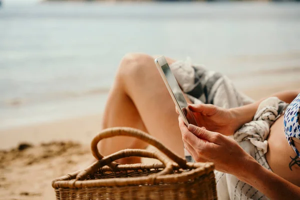 Caucasian female teen relaxing on beach reading book on digital tablet — Stock Photo, Image