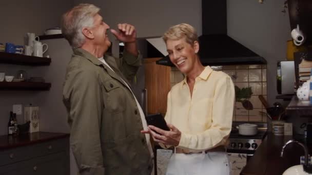 Caucasico maturo coppia ridere di messaggio in il cucina — Video Stock