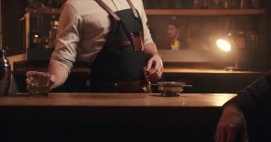 Kafkasyalı erkek müşteri barda tek başına içki içerken barmenle takılıyor. 