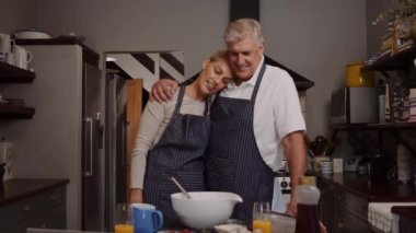 Romantik yaşlı çift mutfakta birlikte yemek pişiriyor.