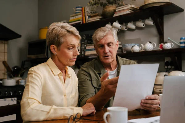 Caucasian senior couple working from home looking at bills and payments
