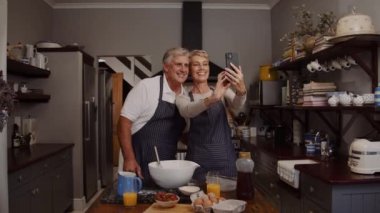 Kafkasyalı yaşlı çift mutfakta selfie çekiyor.
