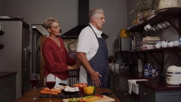 Sevecen yaşlı çift mutfakta yemek pişiriyor. — Stok video