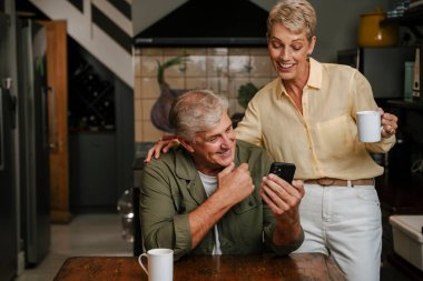 Kafkasyalı yaşlı çift mutfakta kahve içiyor. 