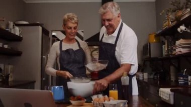 Mutfakta yemek pişirirken gülen sevimli yaşlı çift. 