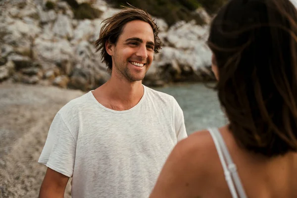 Blank man glimlachen naar vriendin terwijl lopen langs het strand — Stockfoto