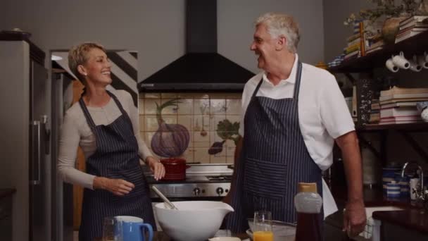 Χαριτωμένο ηλικιωμένο ζευγάρι ψήσιμο στην κουζίνα — Αρχείο Βίντεο