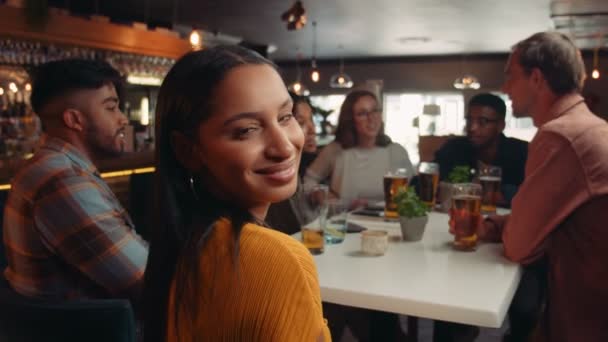 Schöne Frau lächelt in die Kamera und trifft sich mit Freunden zum Abendessen — Stockvideo