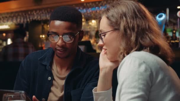 Biracial work colleagues chatting business in restaurant on the tablet together — Stock Video