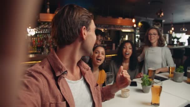 Разнообразная группа друзей выходит на ужин, делая селфи и вызывая друзей по видеосвязи — стоковое видео