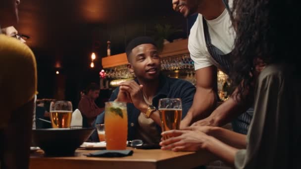 Camarero afroamericano colocando factura recogiendo comida de los clientes después de la cena celebratoria — Vídeo de stock