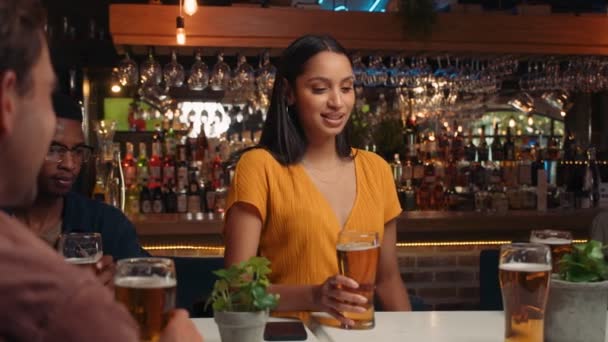 Hermosa joven diciendo un discurso y haciendo un brindis con diversos grupos de amigos bebiendo cerveza en el restaurante — Vídeos de Stock