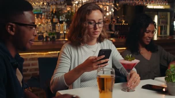 Zróżnicowana grupa przyjaciół pijących drinki w restauracji robiących zdjęcia koktajli — Wideo stockowe
