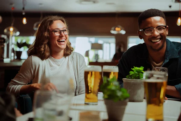 Diverse friends out for dinner drinking beers — Foto de Stock