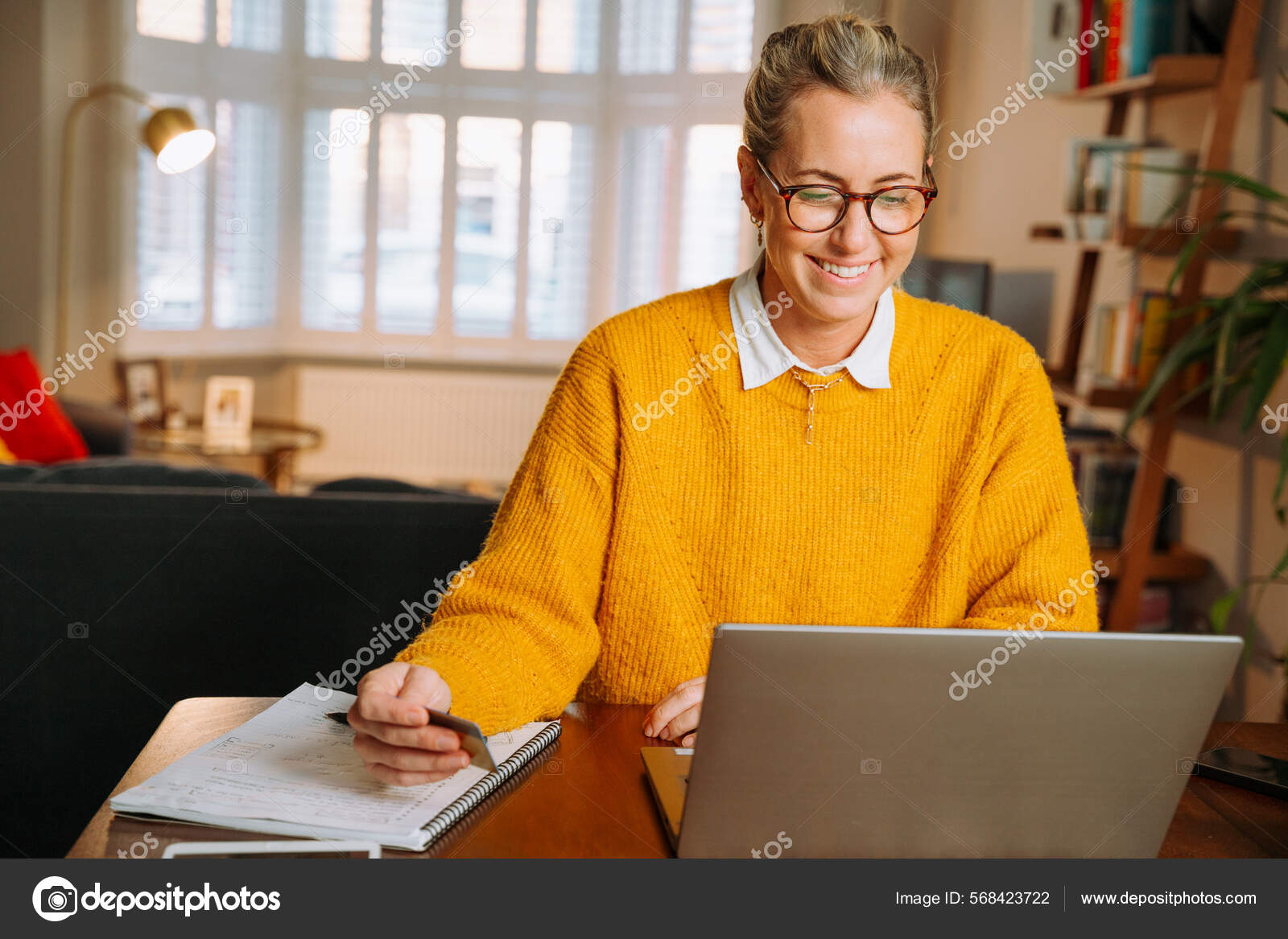 在客厅工作的白人女性自由职业——图库图片© PrinsProduction #568423722