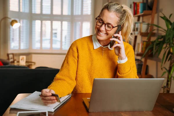 Caucasian female working at home engaging in phone call — Foto Stock