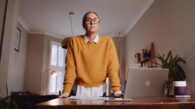 caucasian female free lance worker working from home at desk