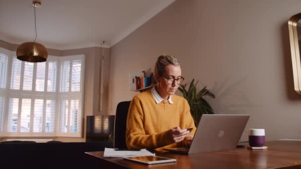 Caucasian female making payment online using laptop — стоковое видео