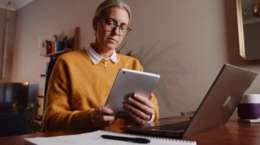 caucasian female working from home typing on digital tablet
