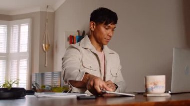 Tablet ve laptop kullanan Asyalı adam