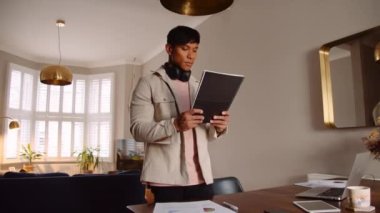 Asyalı erkek laptopuyla evde mutlu mesut çalışıyor. 