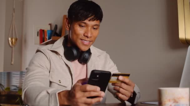 Asiatischer Mann zahlt auf seinem Handy — Stockvideo